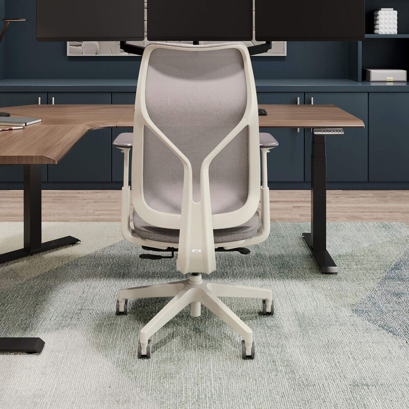 Rear view of cloud white Vari Align office chair with Alloy Grey mesh backrest and adjustable armrests, positioned in front of a desk with dual monitors. image number null